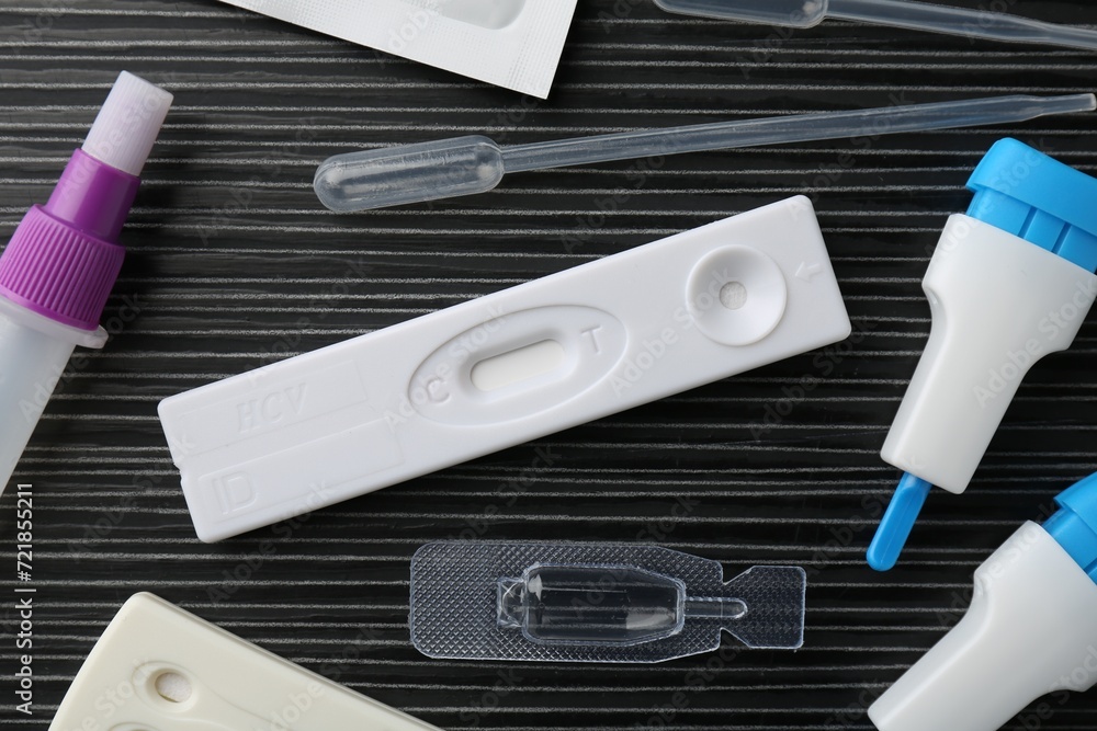 Disposable express test kits on black wooden table, flat lay Disposable express test kits on black wooden table, flat lay