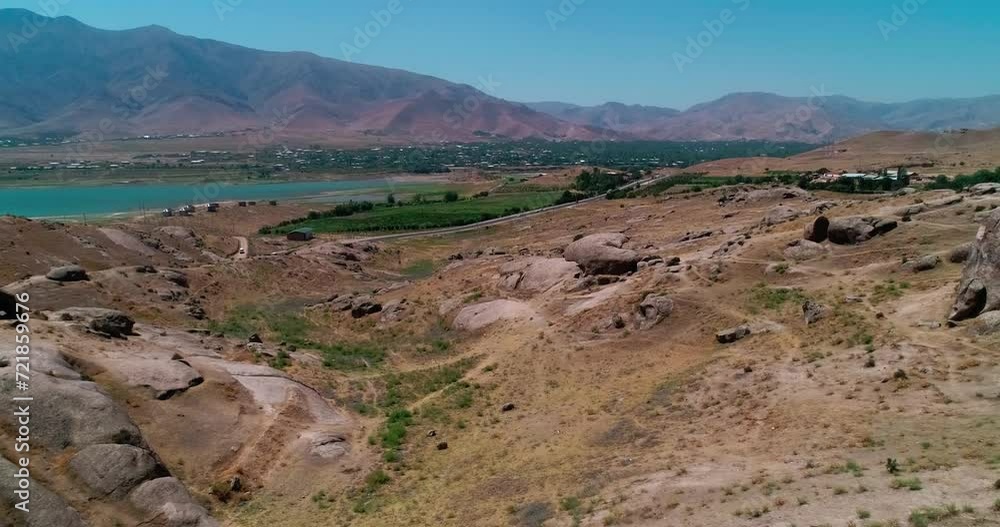 The drone flies over the hills, including a small town on the shores of a mountain lake The drone flies over the hills, including a small town on the shores of a mountain lake