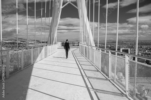 
photo of an overpass with black and white lines, shadows and poles