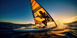 An active windsurfer rides the waves with a colorful sail against a stunning sunset over the sea