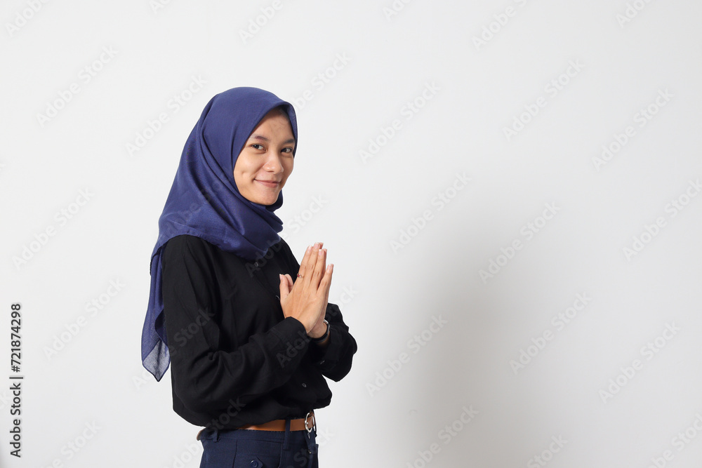 Portrait of excited Asian hijab woman in casual suit showing apologize and welcome hand gesture. Businesswoman concept. Isolated image on white background Portrait of excited Asian hijab woman in casual suit showing apologize and welcome hand gesture. Businesswoman concept. Isolated image on white background