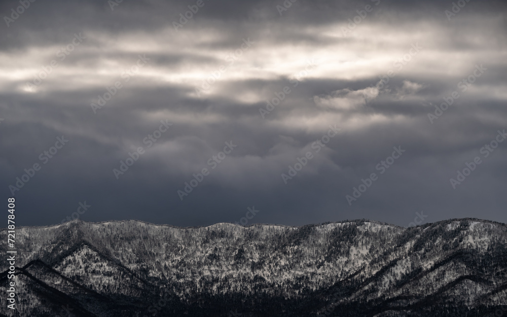 曇り空の下の雄大な雪山