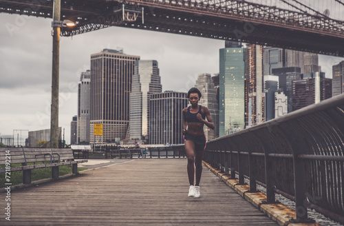 Athlete woman training in the morning at sunrise in New york city, Brooklyn in the background © oneinchpunch
