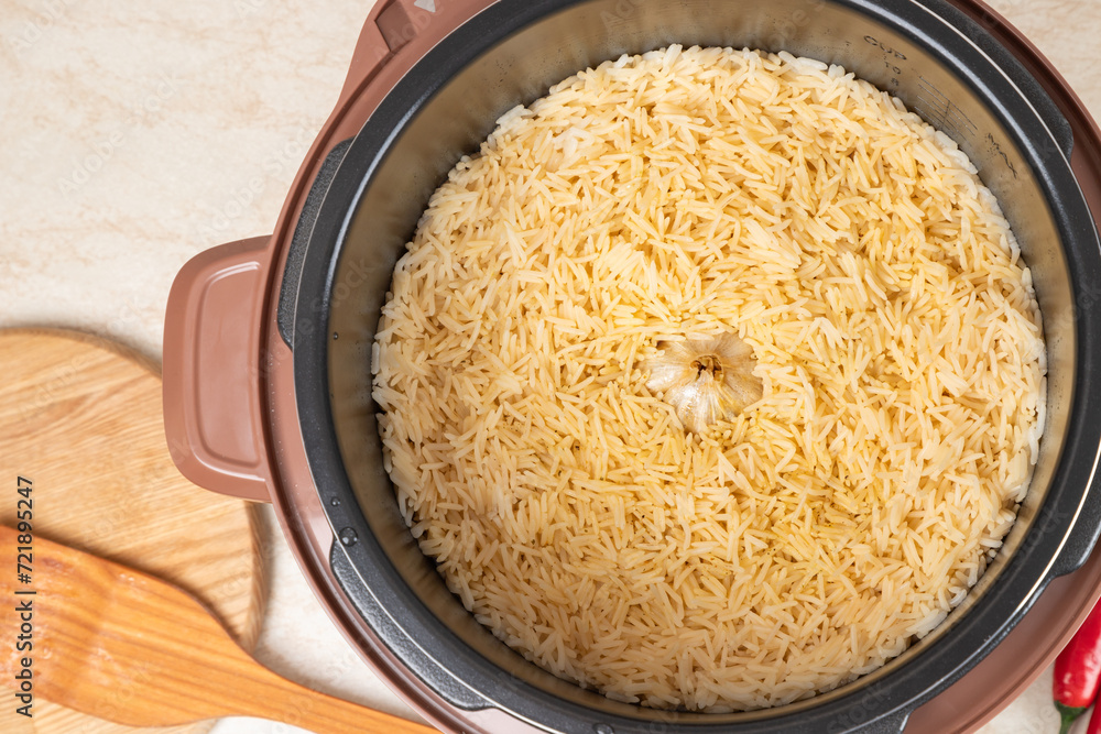 Just cooked pilaf with turkey, mutton, beef or pork, carrots, onions, garlic, pepper and raisin in the modern multicooker. A traditional dish of Asian cuisine. Just cooked pilaf with turkey, mutton, beef or pork, carrots, onions, garlic, pepper and raisin in the modern multicooker. A traditional dish of Asian cuisine.