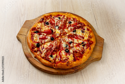 Meat pizza. On a light wooden background.