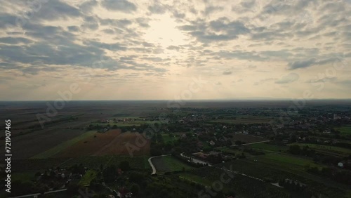 Aerial footage of serene countryside and river under cloudy sky in sunset photo