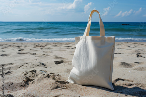 White tote bag on sandy beach with blue ocean in the background. Mockup with copy space. Summer vacation and eco-friendly concept design