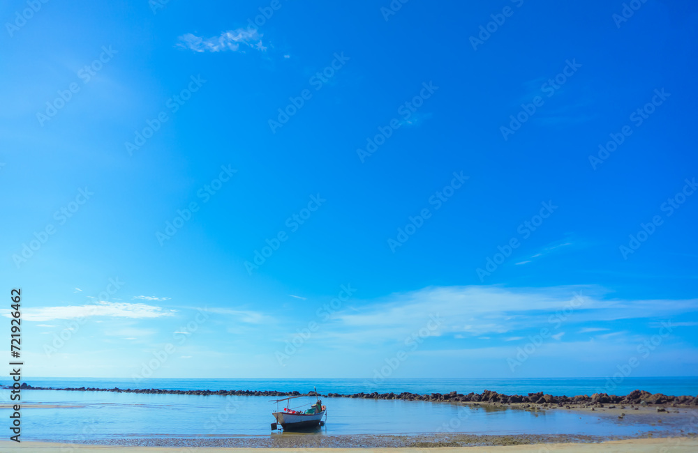 Small fishing boats of local fishermen  Parked at the seaside with a sandy beach and rocks