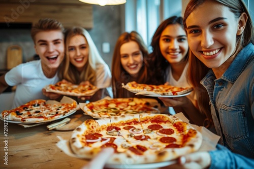Feeling hungry. Group of young people in casual wear eating pizza and smiling while having a dinner party indoors
