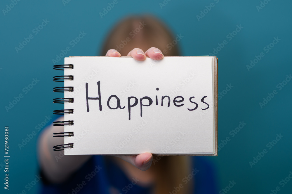 Kobieta trzyma w dłoni z napisanym słowem szczęście w języku angielskim - obrazy, fototapety, plakaty 