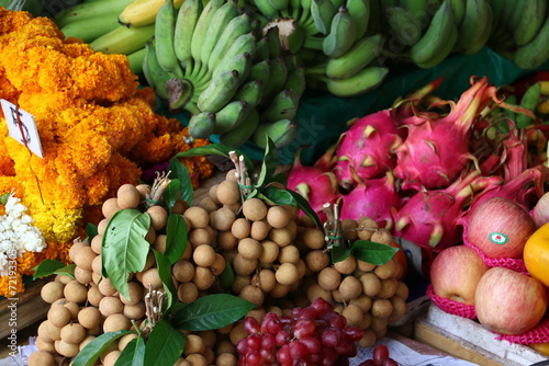 Fototapeta Naklejka Na Ścianę i Meble -  Langsat, Dragon Fruit, Bananas and Flowers on a Market Stall in Cambodia