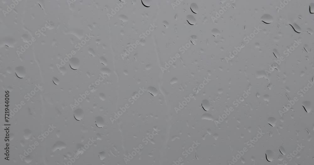 A raindrops on a window, with a view of a cloudy sky. pano