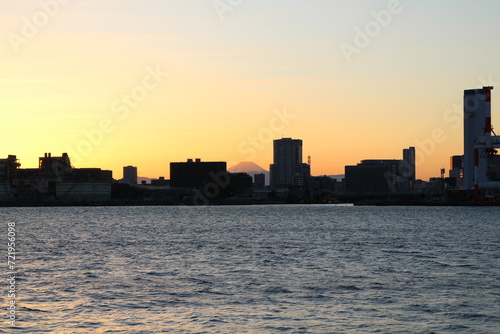 Mount Fuji over modern buildings in dusk viewed from Tokyo Bay, Japan © HanzoPhoto