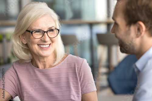 Bild auf Leinwand Happy attractive senior businesswoman talking to younger colleague man on busine