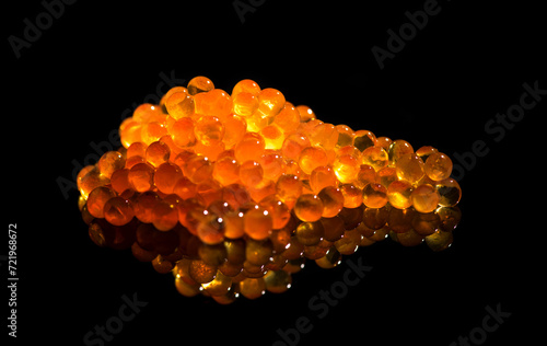 Red caviar close up. Salmon caviar isolated on black background. Delicious gourmet food.  Delicatessen. Texture of caviar. Seafood, macro shot 