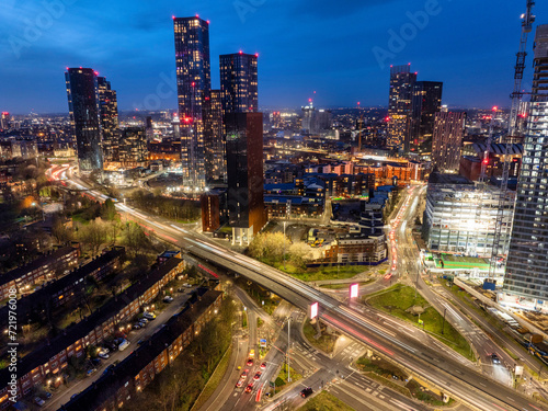 Aerial image of Manchester skyline early night showing new urban developments and trail of lights from the traffic. 