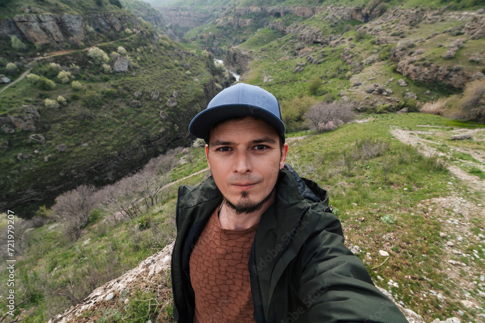 bearded Caucasian male traveler takes a selfie on a smartphone against the background of Aksu Canyon in Kazakhstan in spring bearded Caucasian male traveler takes a selfie on a smartphone against the background of Aksu Canyon in Kazakhstan in spring