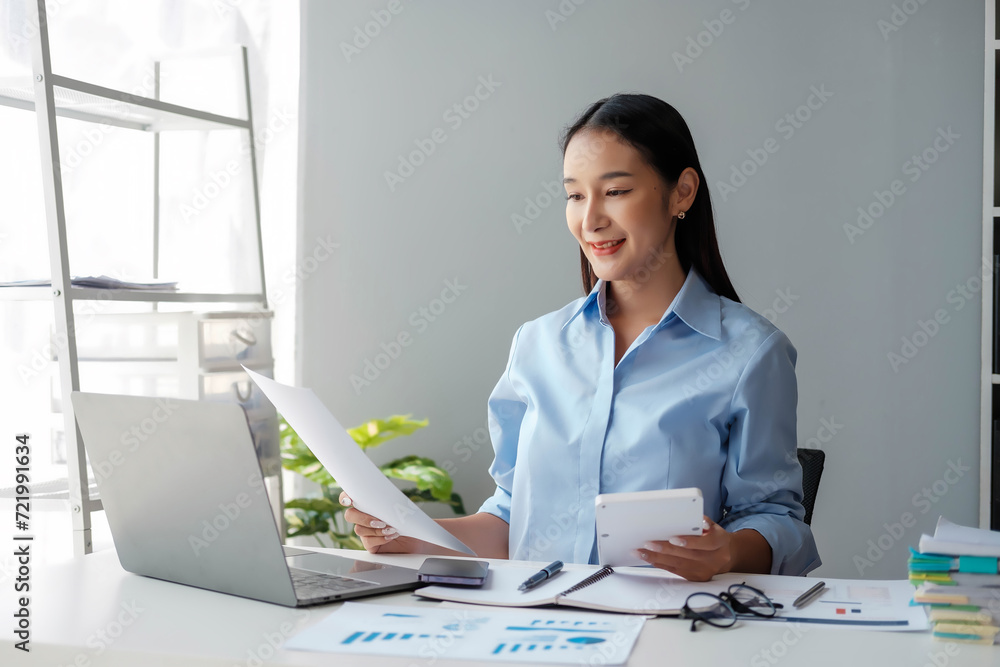 Young happy businesswoman using computer in office, Stylish Beautiful Manager Smiling, Working on Financial and Marketing Projects, Portrait of a young businesswoman working on a laptop in an office Young happy businesswoman using computer in office, Stylish Beautiful Manager Smiling, Working on Financial and Marketing Projects, Portrait of a young businesswoman working on a laptop in an office