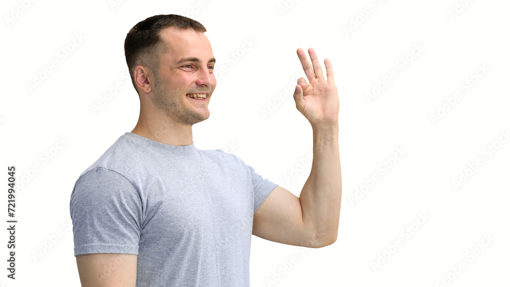 Fototapeta premium A man in a gray T-shirt, on a white background, close-up, shows the ok sign
