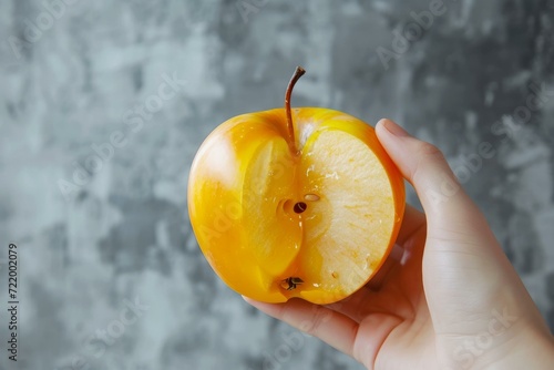Hand holding a cross section of a yellow apple photo