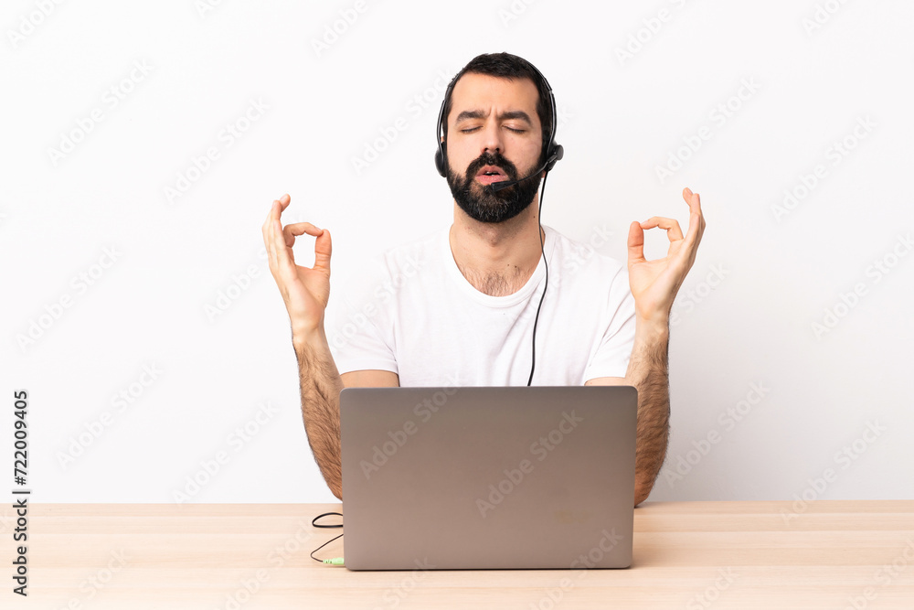 Telemarketer caucasian man working with a headset and with laptop in zen pose. Telemarketer caucasian man working with a headset and with laptop in zen pose.