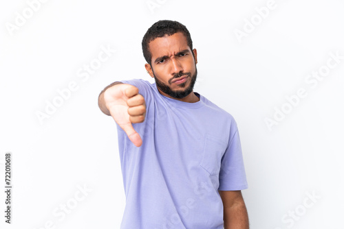 Young Ecuadorian man isolated on white background showing thumb down with negative expression