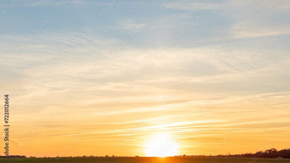 Idyllic view of field and straw rolls against sky during sunset, Lithuania, Europe.