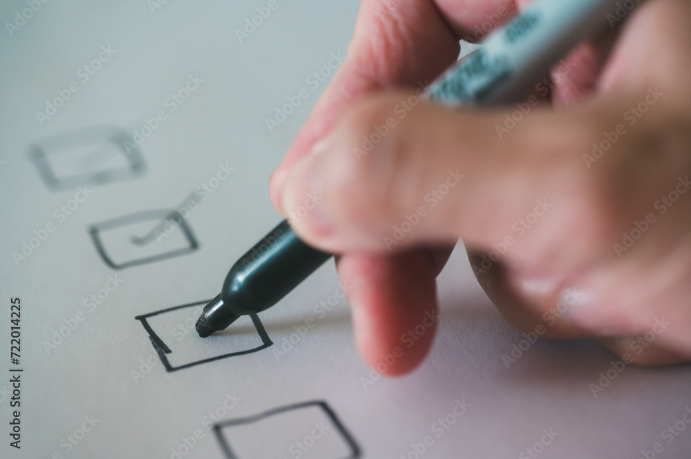 close up and selective focus hand using pen to making tick mark on check list box check list and marker close up and selective focus hand using pen to making tick mark on check list box check list and marker