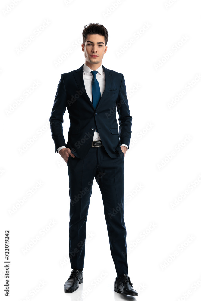 elegant young businessman in navy blue suit holding hands in pockets elegant young businessman in navy blue suit holding hands in pockets
