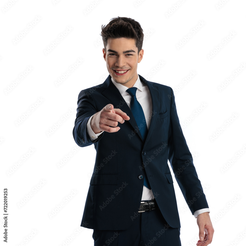 confident elegant man in navy blue suit smiling and pointing finger forward confident elegant man in navy blue suit smiling and pointing finger forward