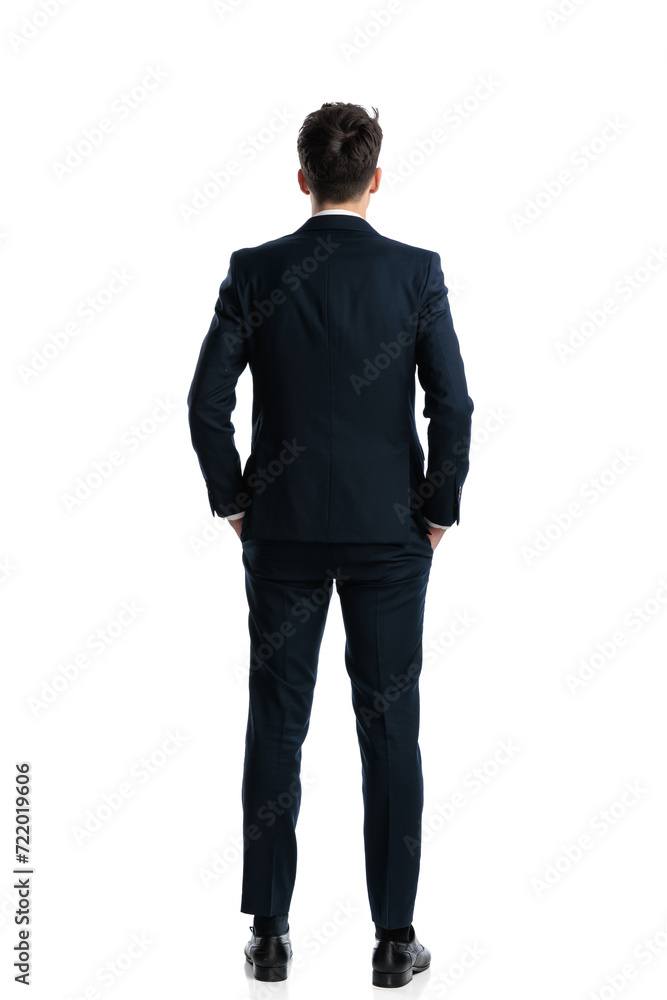 elegant man in navy blue suit holding hands in pockets and standing elegant man in navy blue suit holding hands in pockets and standing