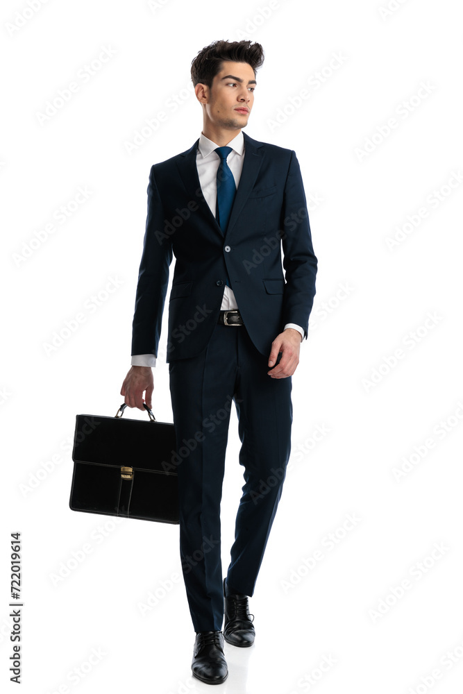 sexy elegant man with suitcase looking to side and walking sexy elegant man with suitcase looking to side and walking