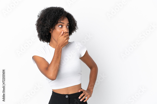 Young African American woman isolated on white background doing surprise gesture while looking to the side