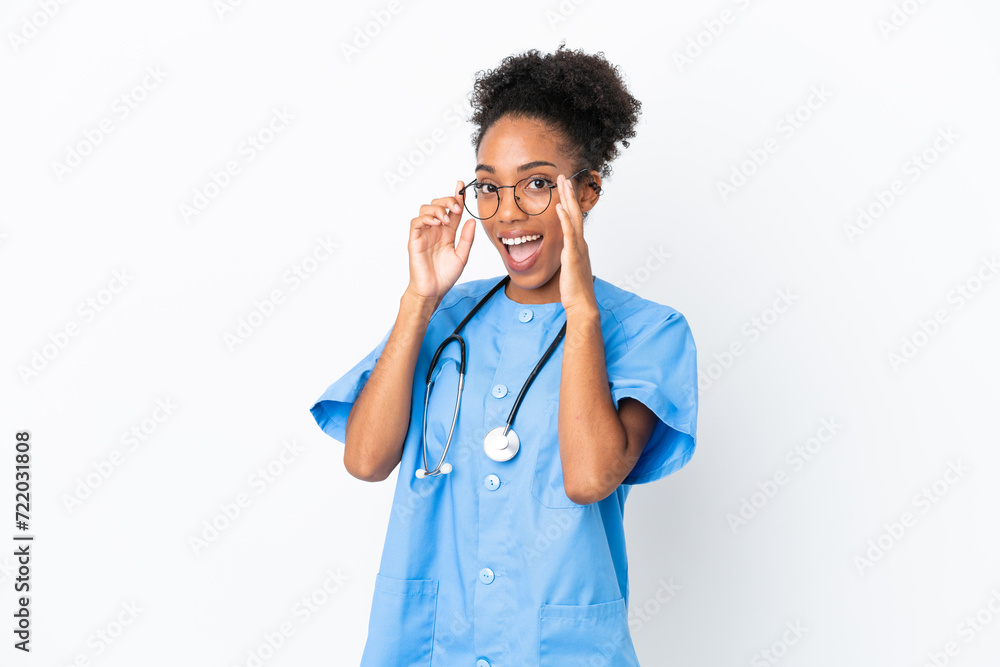 Young surgeon African American doctor woman isolated on white background with glasses and surprised Young surgeon African American doctor woman isolated on white background with glasses and surprised