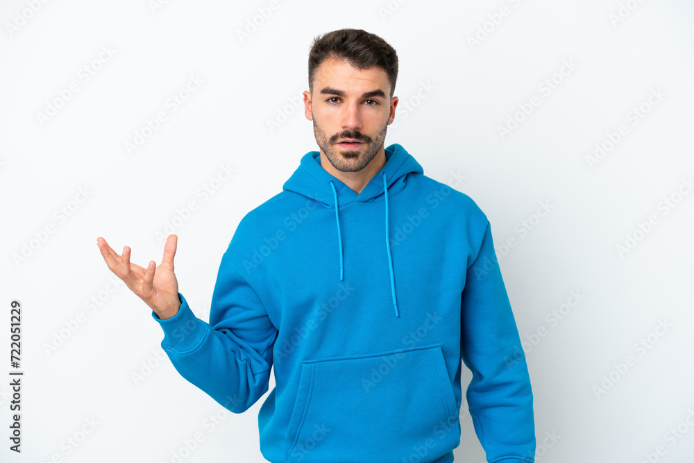Young caucasian man isolated on white background making doubts gesture Young caucasian man isolated on white background making doubts gesture