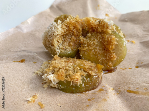 Lopis, traditional snack from indonesia, made from glutinous rice cake, sliced and served with grated coconut and liquid brown sugar photo