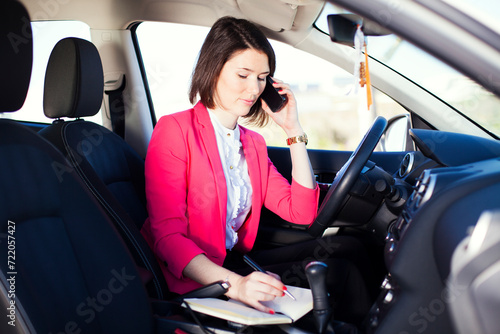 woman maneuvers her car, effortlessly multitasking as she engages in conversation on her mobile phone