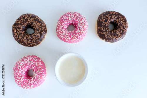 Styled stock photo. Donuts, two golden rings, and a cup of coffee on a white table. Retro style.Concept of breakfast. Food detail. Close up. Pastel color.