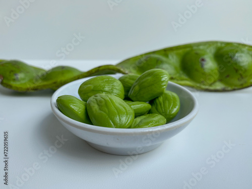 Parkia speciosa, the bitter bean, petai, or pete. Before and after peeled. Isolated on white background photo