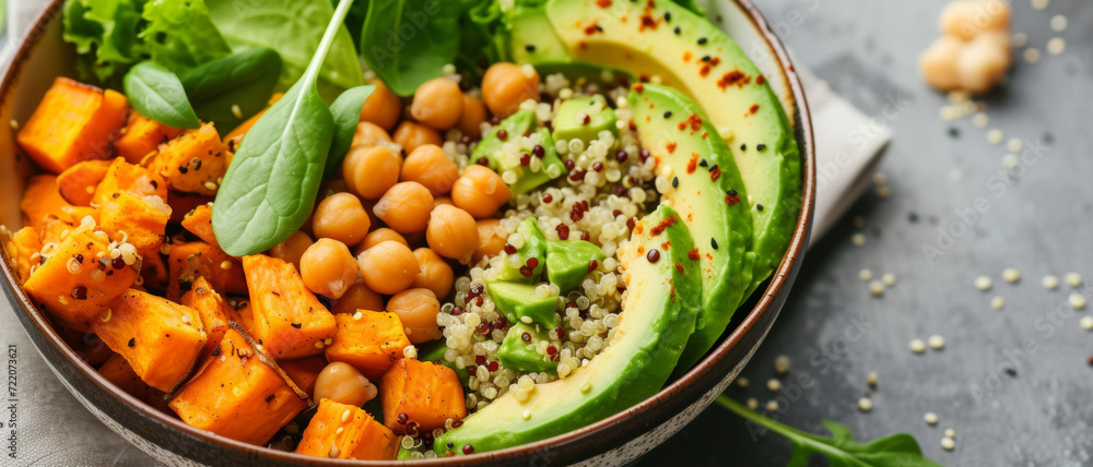 Wholesome vegan buddha bowl with quinoa, chickpeas, avocado, sweet potato, and leafy greens, seasoned with spicy pepper flakes Wholesome vegan buddha bowl with quinoa, chickpeas, avocado, sweet potato, and leafy greens, seasoned with spicy pepper flakes