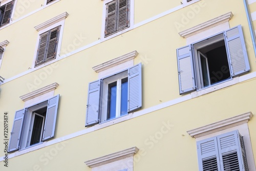 Residential building with windows and wooden shutters, low angle view