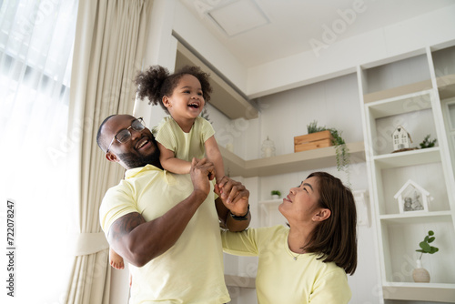 Family Leisure. Happy Black Mom, Dad And Little Daughter Having Fun At Home Together, African American Father, Mother And Cute Female Child Playing In Living Room And Smiling At Camera, Free Space