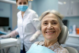 A senior woman beams with a healthy smile while seated in a dental chair. Satisfied senior woman at dentist's office looking at camera. Dental care concept.