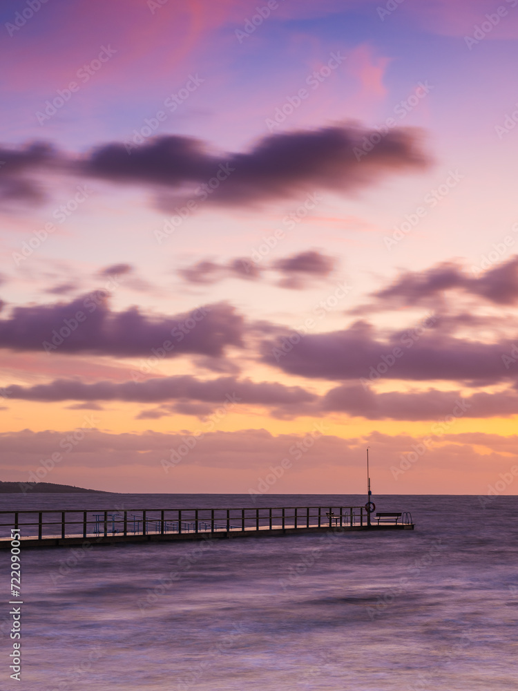 Tranquil Sunset Over Ocean Pier With Vibrant Skies And Calm Waters