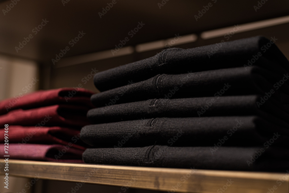 wardrobe with men's clothes in dark colors. jacket, down jacket, shirt. The clothes are neatly hung on wooden hangers wardrobe with men's clothes in dark colors. jacket, down jacket, shirt. The clothes are neatly hung on wooden hangers