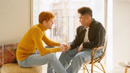 Gay man takes his partner's hand to communicate something