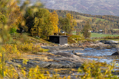 Fototapeta Naklejka Na Ścianę i Meble -  granero para embarcación negro en medio de bosque en otoño