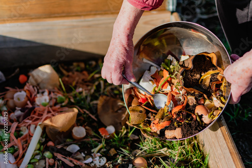 Person who put in a composter some kitchen waste like vegetables, fruits, eggshell, coffee grounds in order to sort and make bio fertilizer