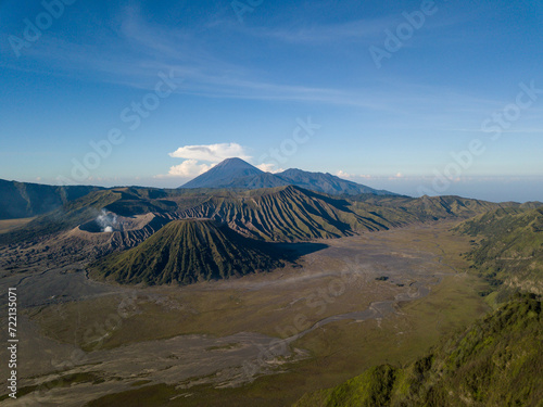 A majestic aerial view of a volcanic mountain landscape under a clear sky.