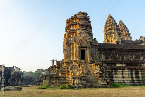 Konstfotografi Person with outstretched arms in front of an ancient temple at sunrise